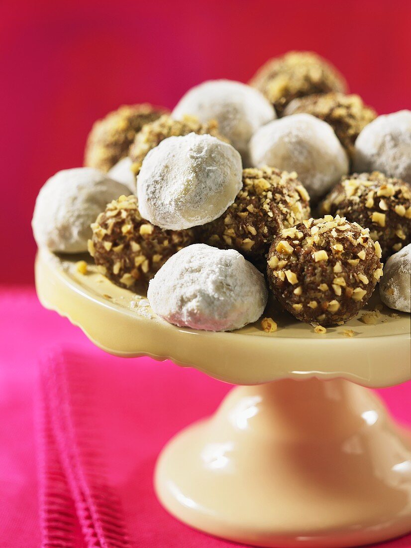 Fudge balls with icing sugar and chopped nuts