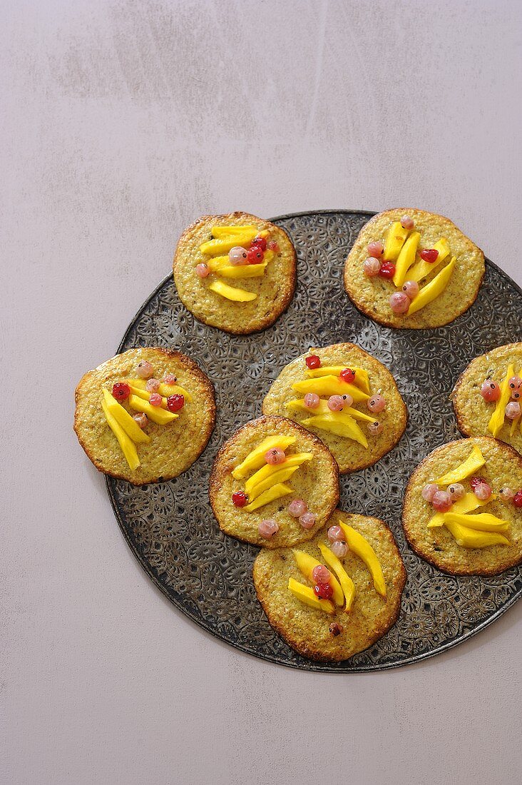 Sweet mini pizzas with bran, mango and redcurrants