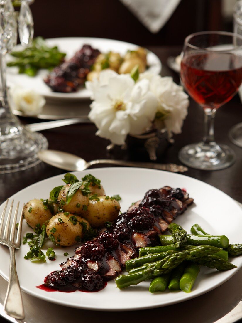 Goose breast with cranberry sauce, herb potatoes and green asparagus
