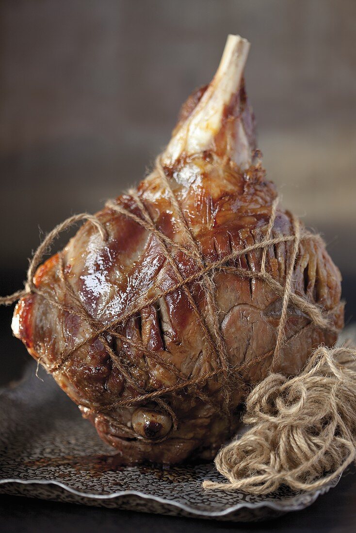 A leg of lamb tied with woll fresh out of the oven