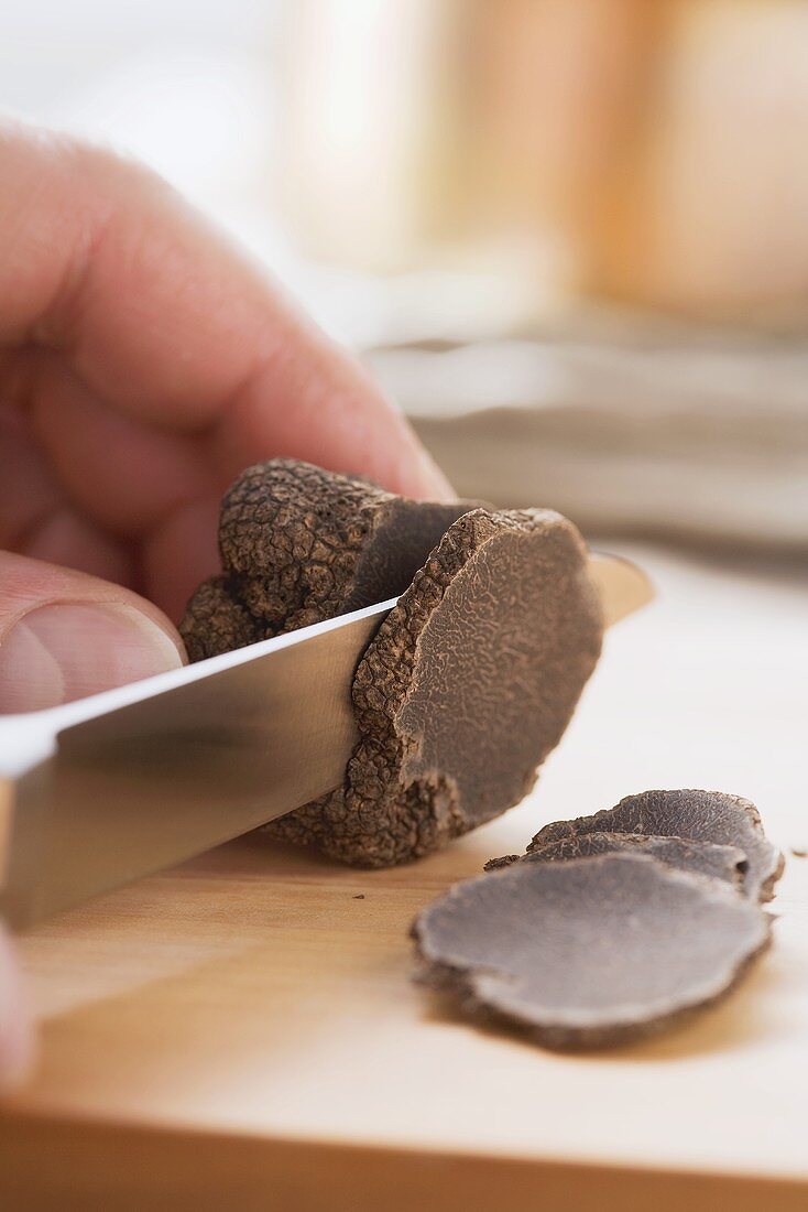 A black truffle being sliced