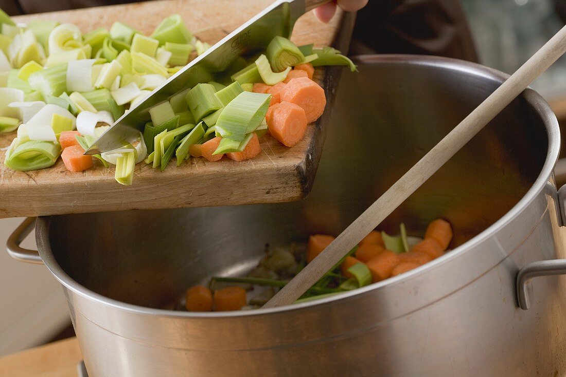 Diced vegetables being added to a pot