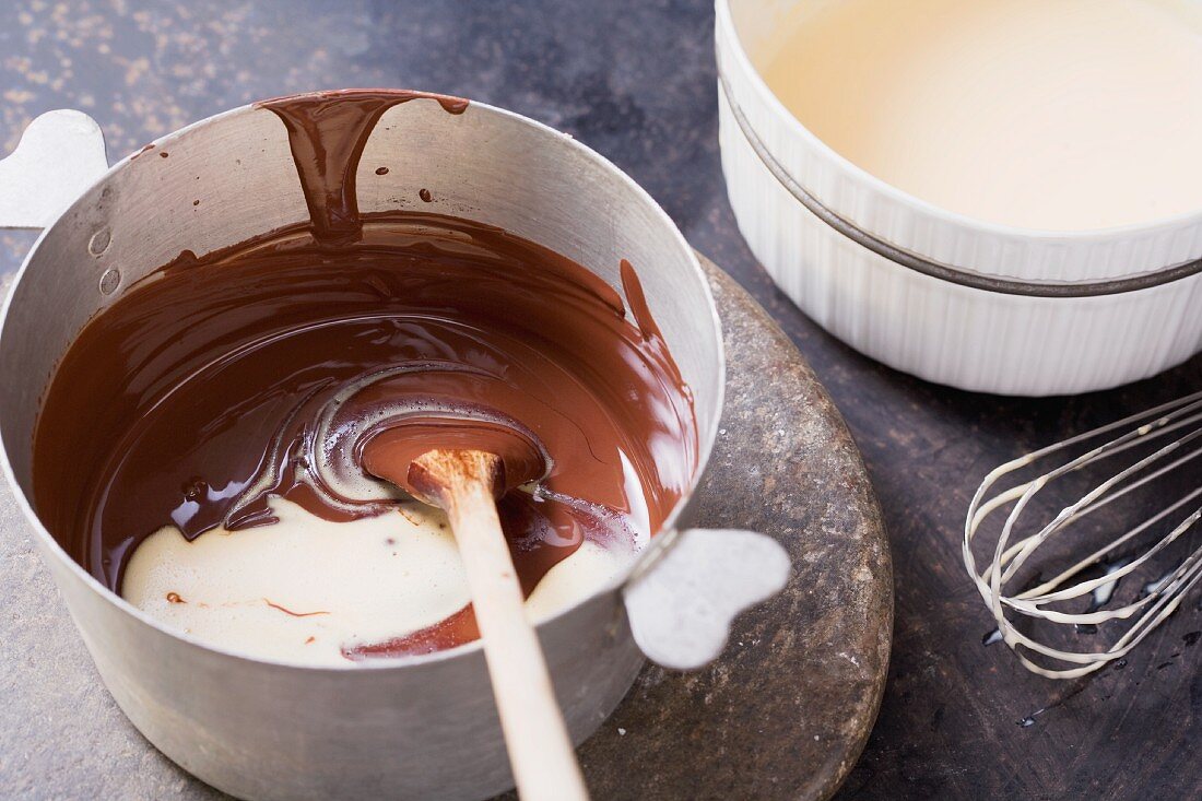 Geschmolzene Schokoladen mit Milch-Sahne-Eigelb-Mischung vermischen