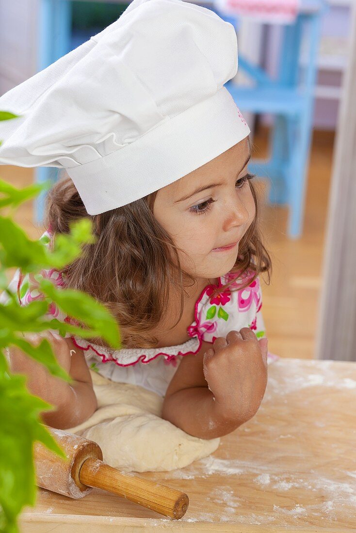 Small girl kneading dough