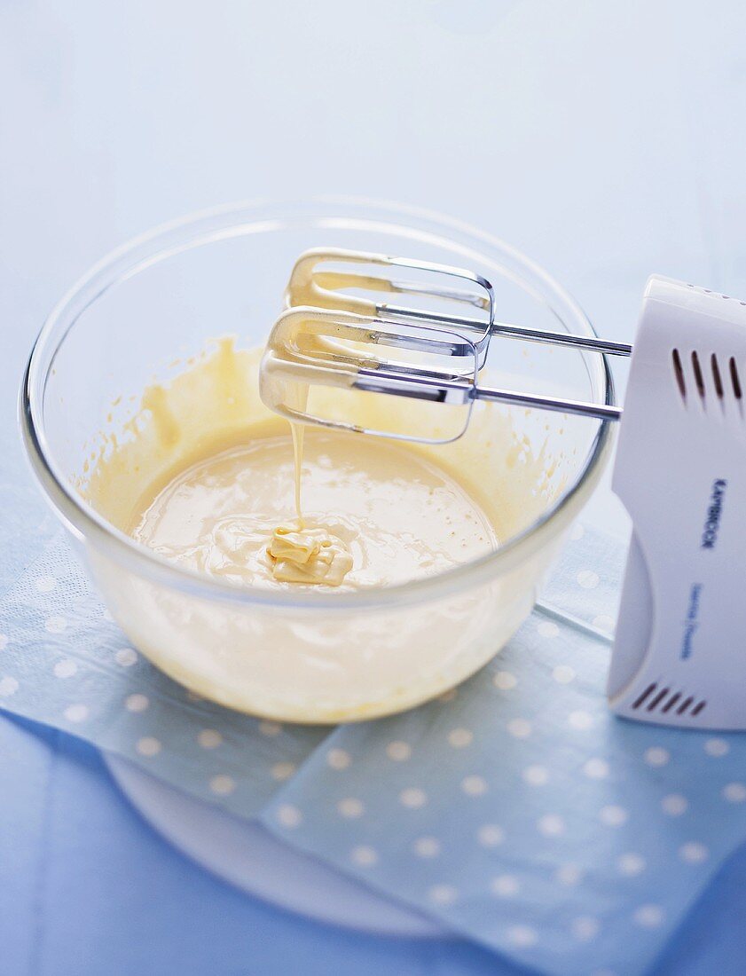 Vanilla ice cream ingredietns: mixing together cream, vanilla, egg yolk with a hand mixer