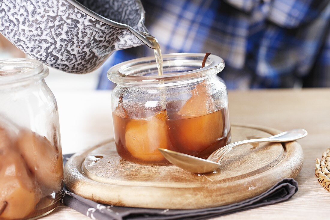 Pouring syrup over poached pears