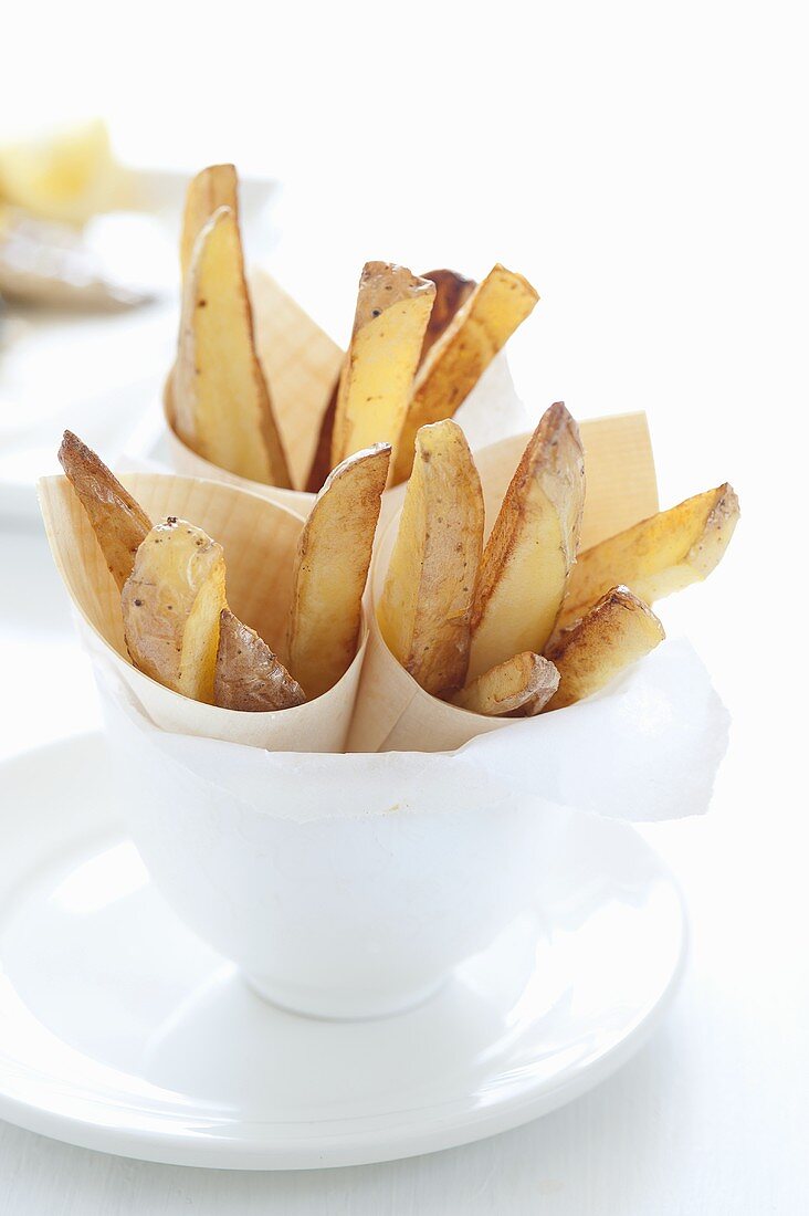 Roasted potato wedges in paper cups