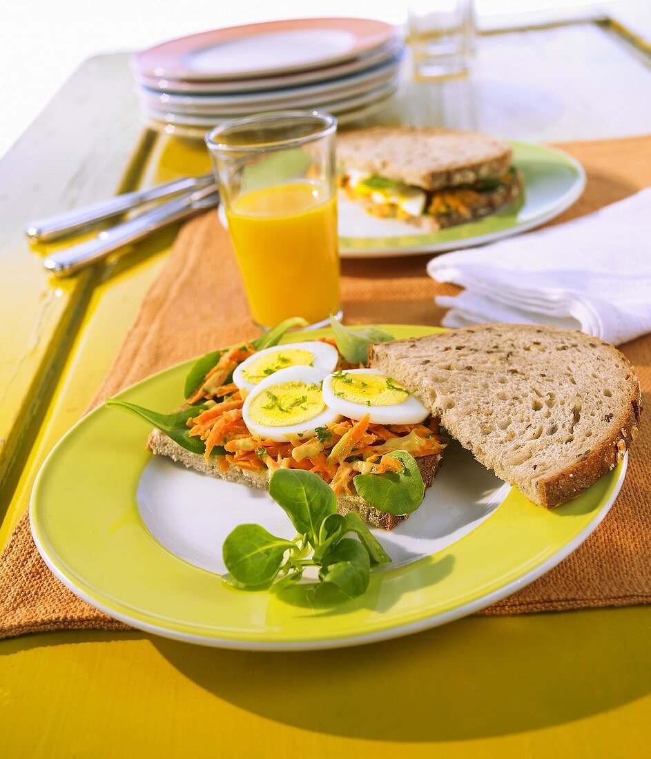 Open faced sandwich with grated carrot, mustard and egg