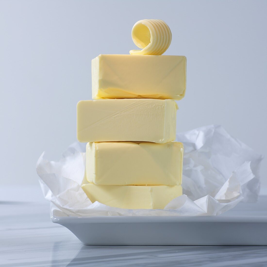 Sticks of butter, stacked, with butter flakes