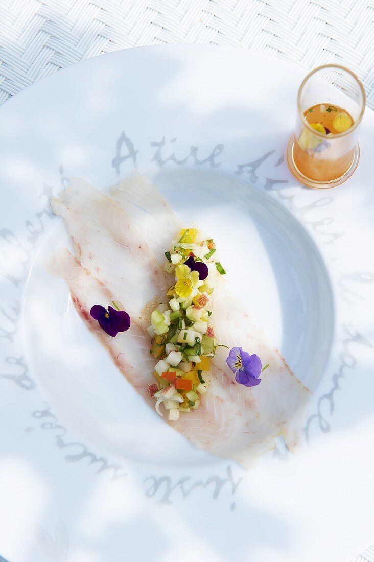Fish fillets with edible flowers and peach ceviche