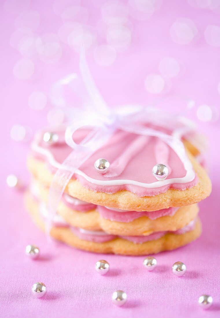 Shell shaped cookies with pink icing and silver pearls