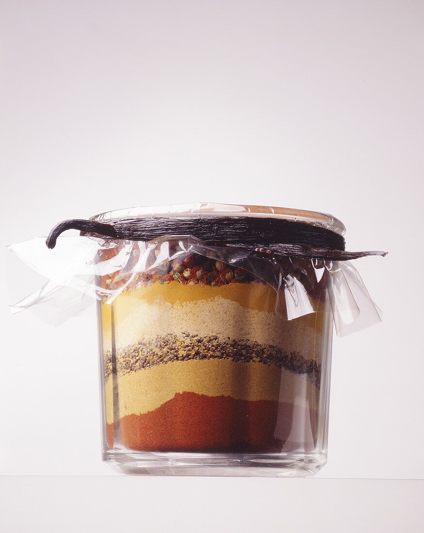 Layered spices closed with a vanilla pod