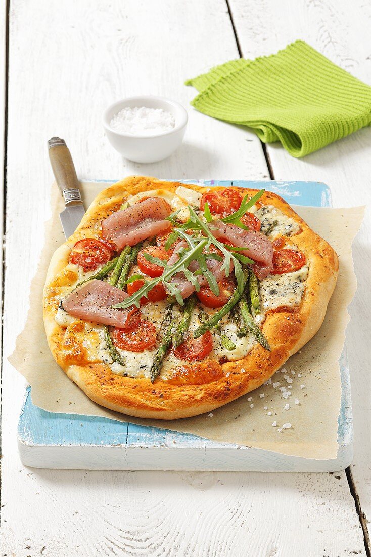 Pizza with asparagus, tomatoes and smoked ham