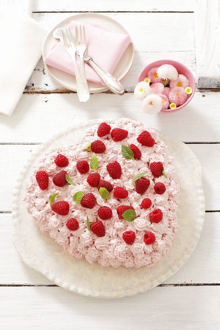 Heart-shaped biscuit cake with cream and raspberries