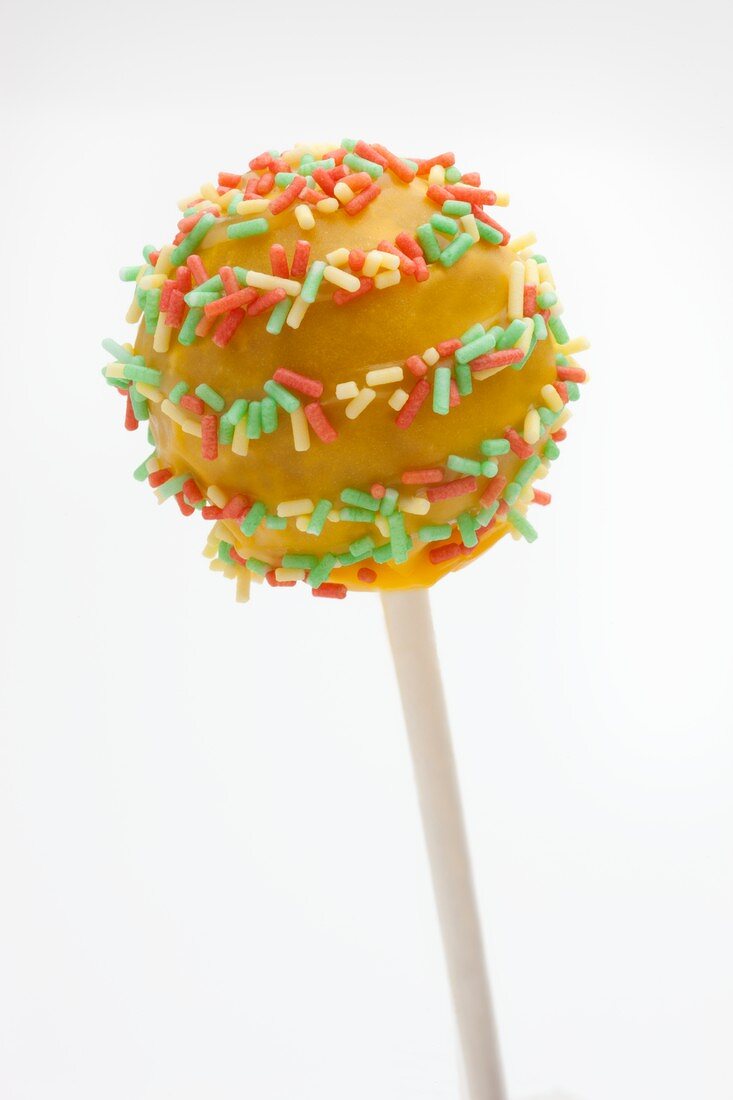 Gelber Cake Pop mit bunten Zuckerstreuseln