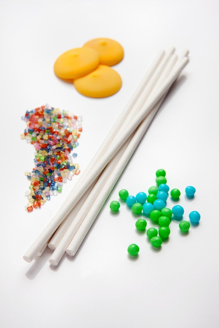 Ingredients for cake pops (sugar beads, sticks, coloured sugar strands and icing drops)