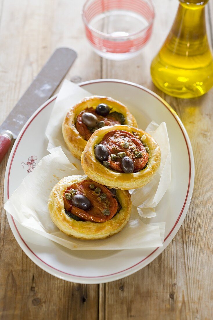 Puff pastry tartlets with tomatoes, courgette and olives
