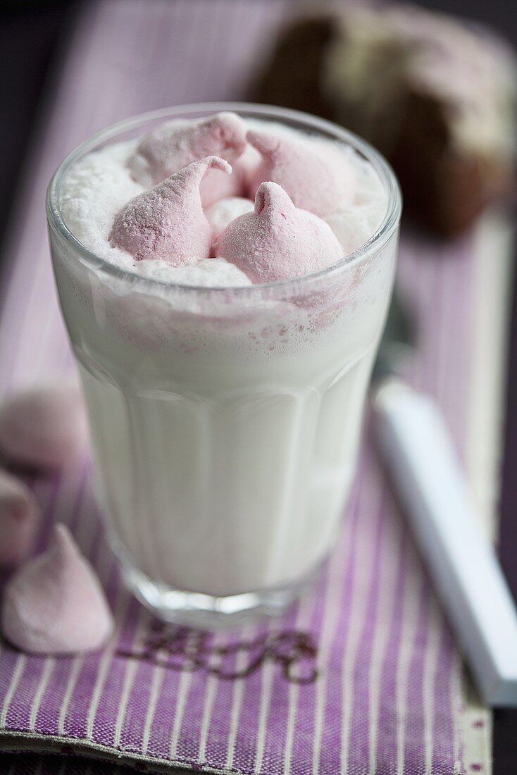 Heiße Milch im Glas mit rosa Marshmallows