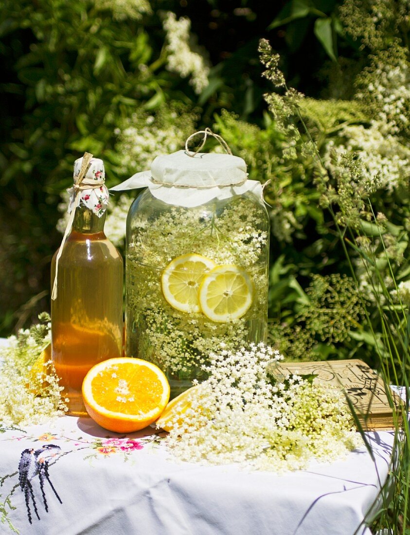 Elderflower syrup and orange syrup on a garden table