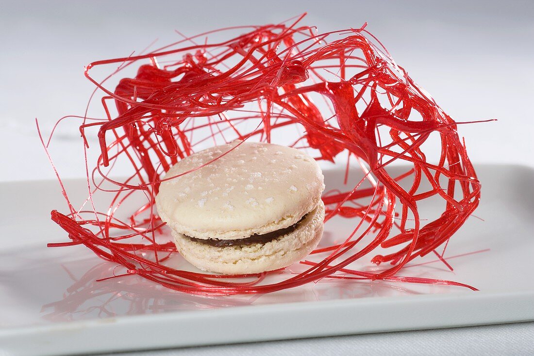 A white chocolate macaroon with red sugar threads