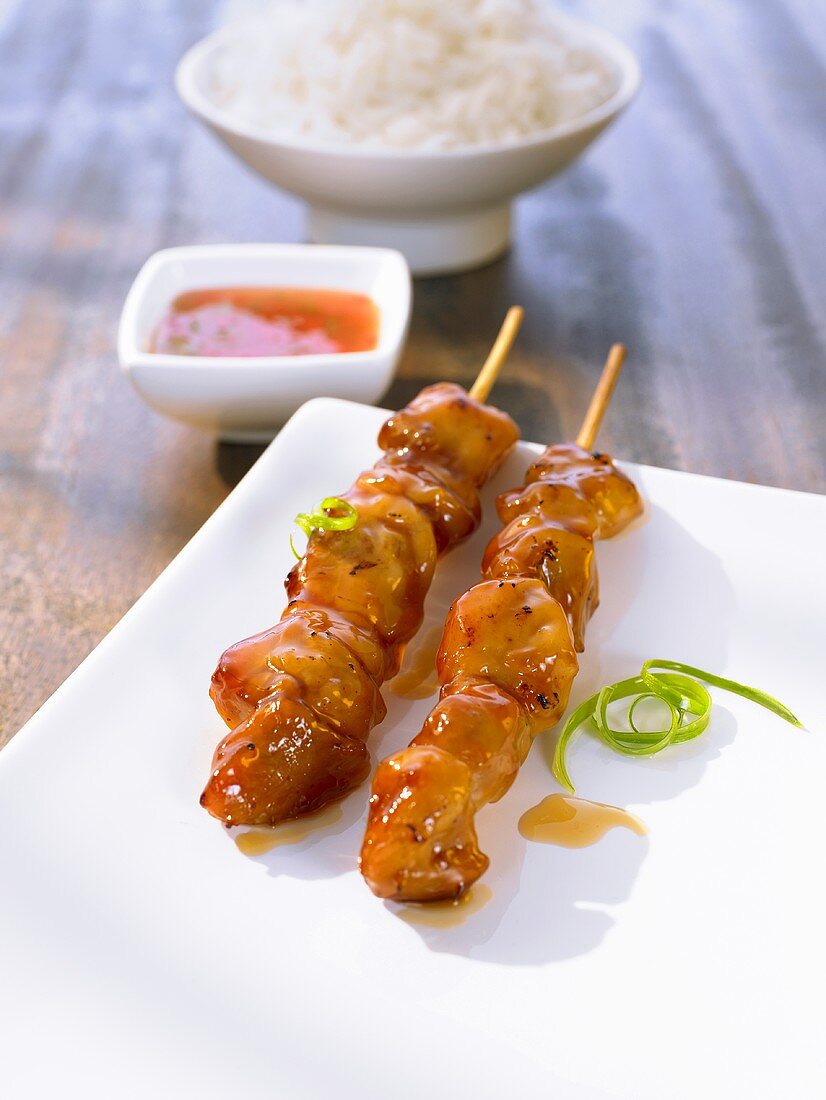 Chicken satay kebabs with a sweet and sour sauce and rice