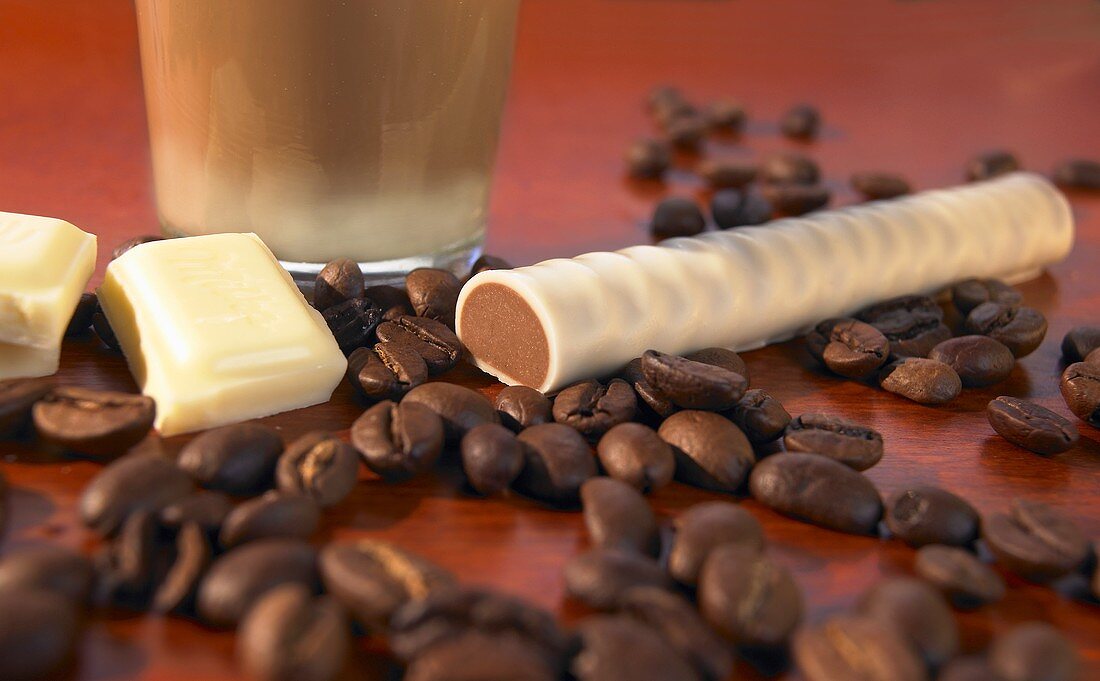 A chocolate latte, a macchiato stick and coffee beans