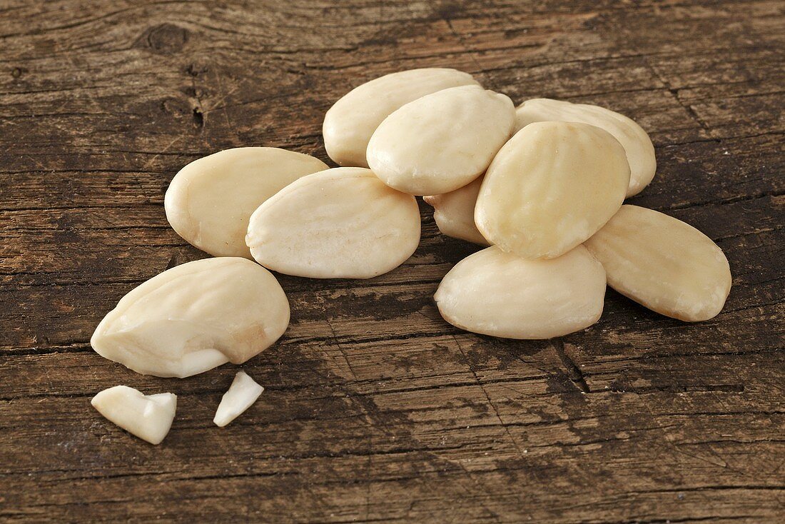 Peeled almonds on a wooden surface
