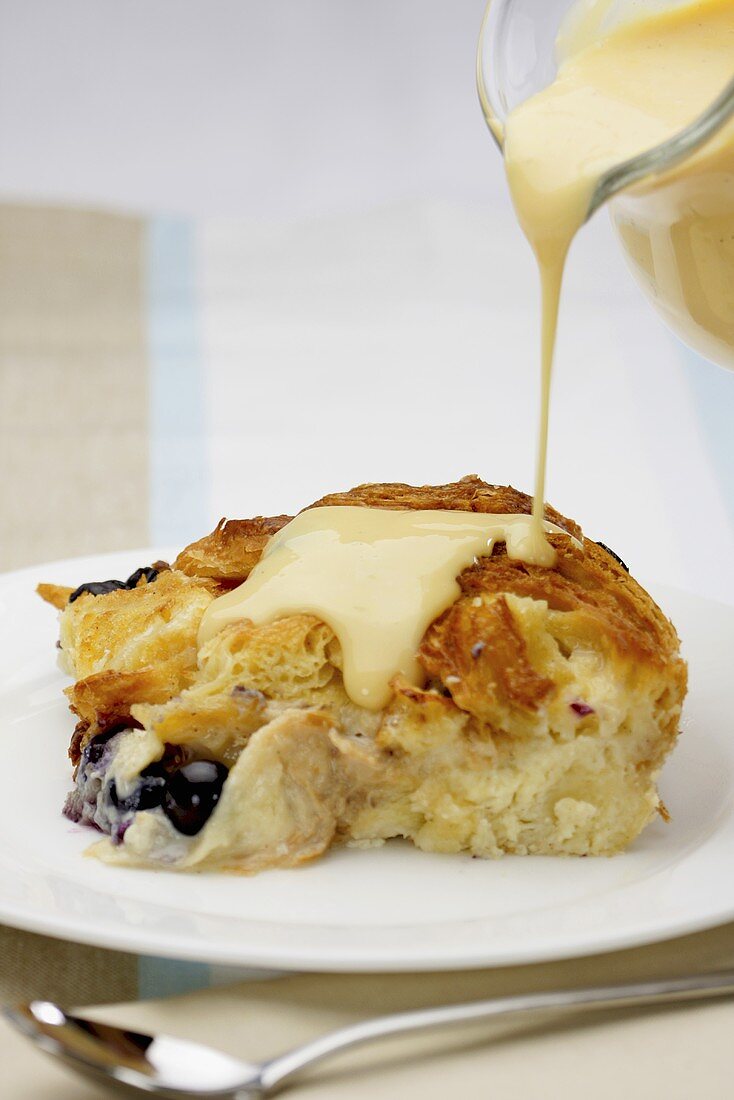 Bread and Butter Pudding mit Vanillesauce begiessen