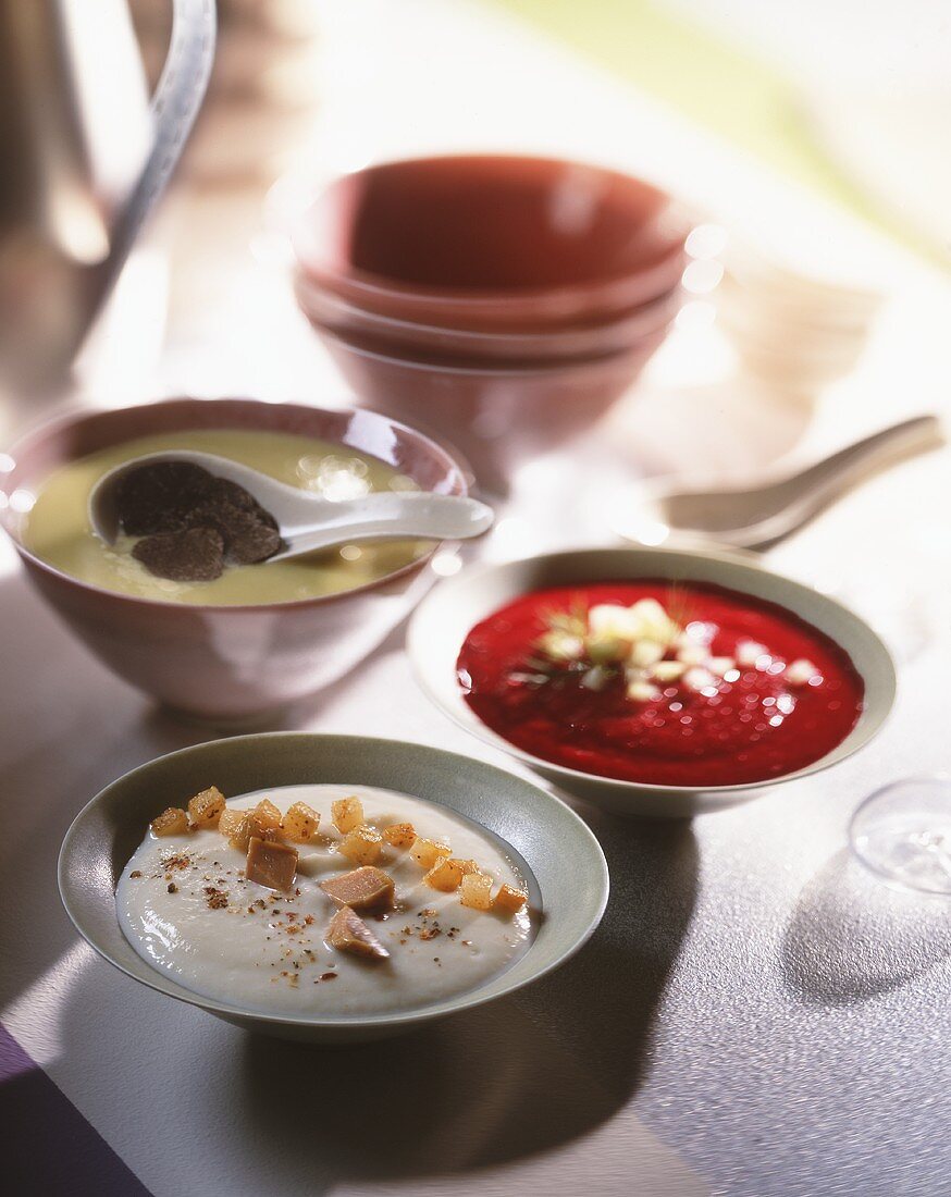 Three desserts in bowls with oriental spoons