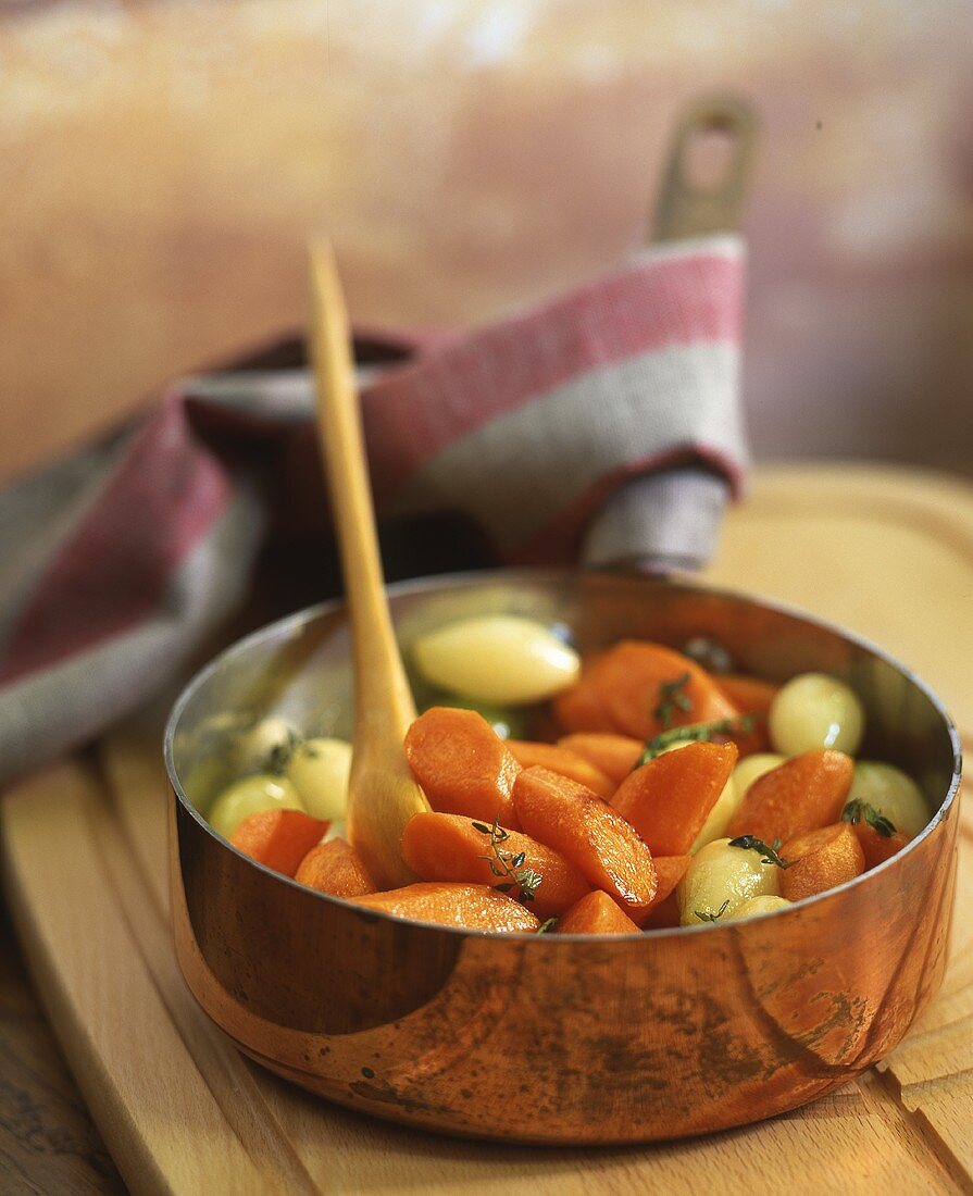 A carrot and onion medley in a copper pot