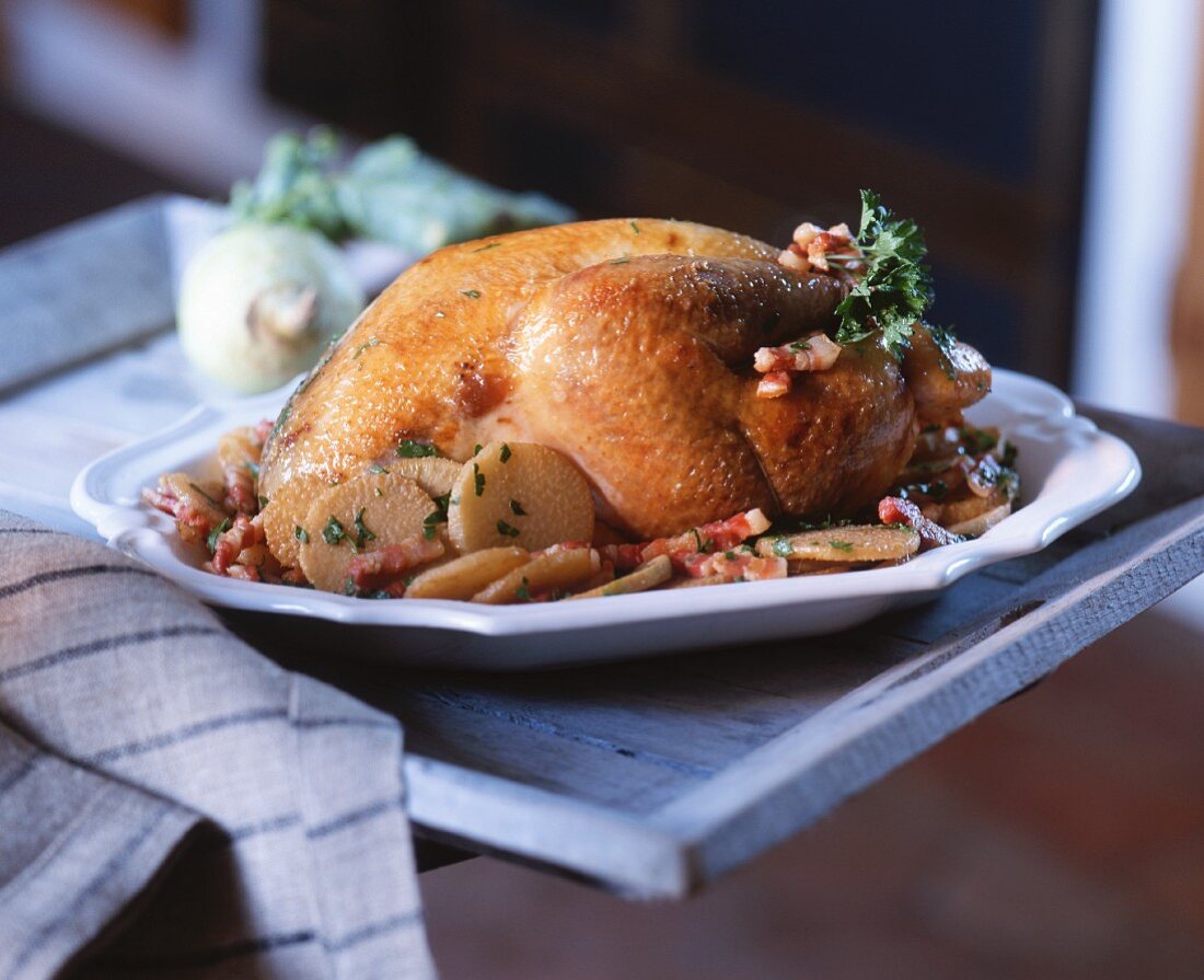 A grilled chicken with potatoes and bacon