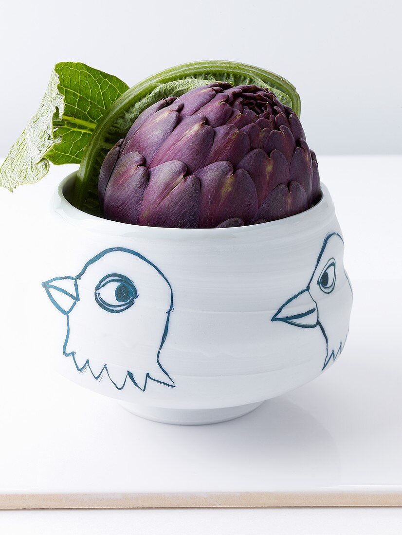 An artichoke in a ceramic bowl