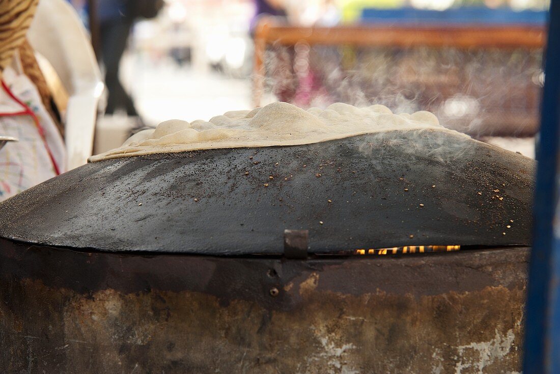 Unleavened bread being baked on a market stand