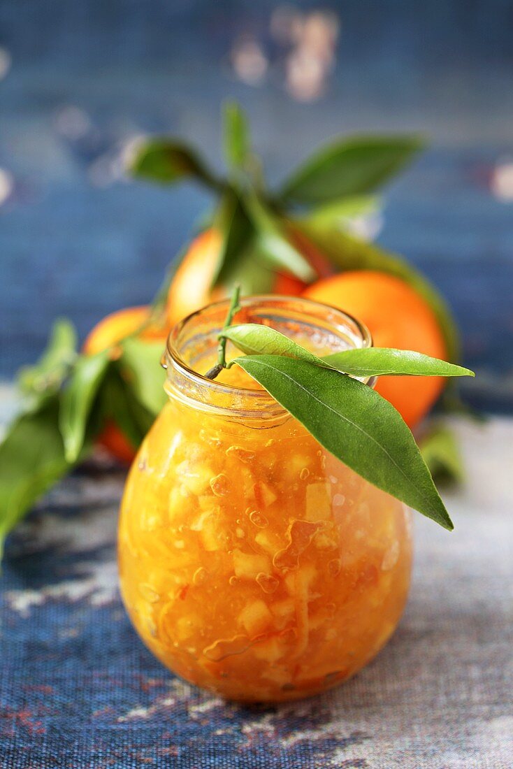 Orangenmarmelade im Glas mit Blättern