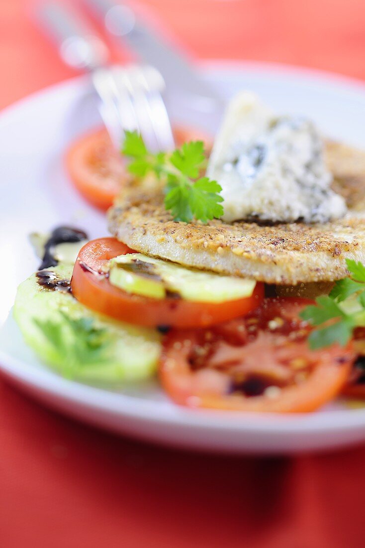 Celery escalope with a nut crust and gorgonzola cream on tomatoes