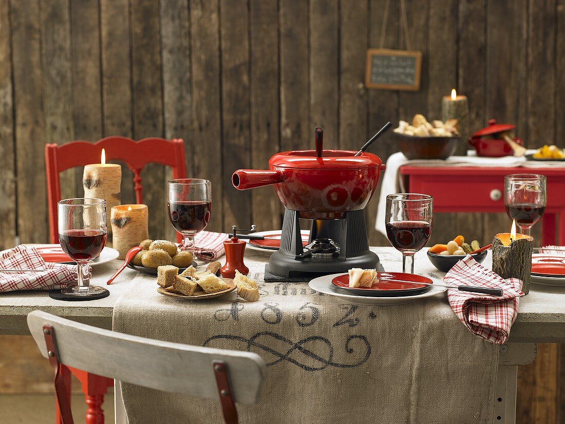 Schweizer Käsefondue mit Kartoffeln, Brot und Rotwein