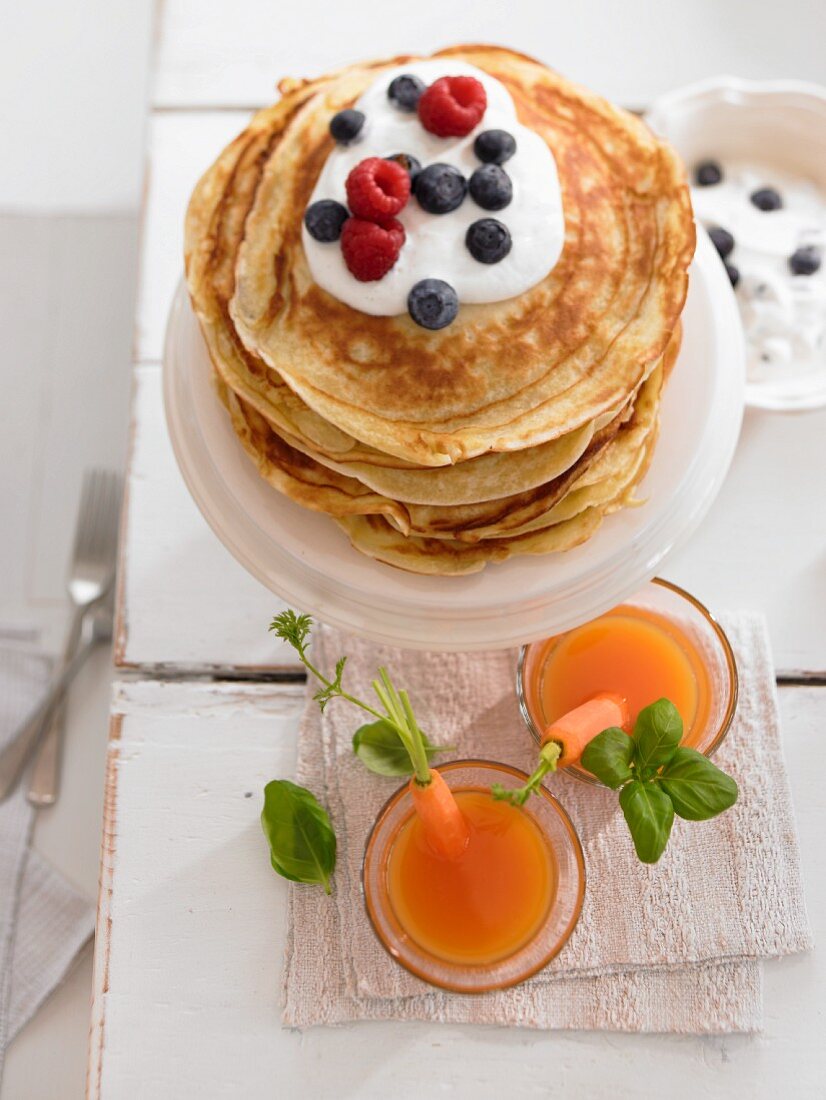 Möhrendrinks und Pfannkuchen mit Joghurt und Beeren