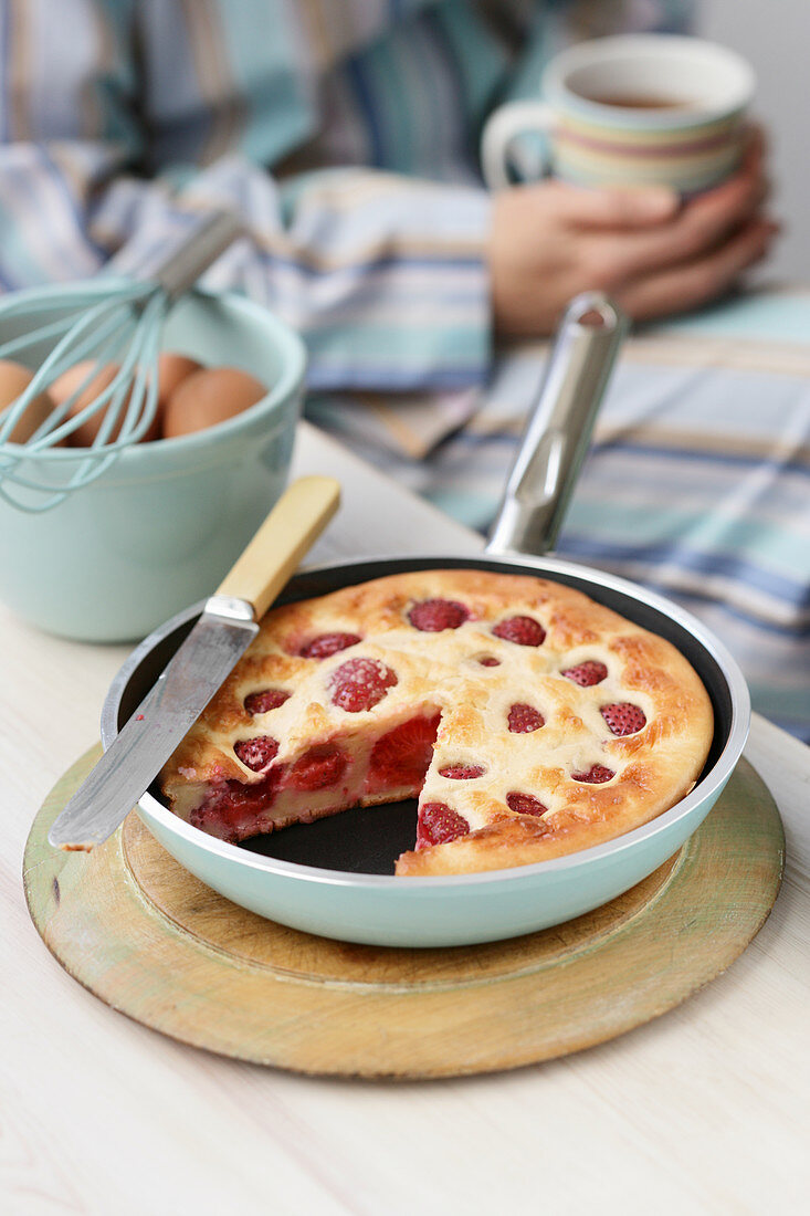 A strawberry pancake in the pan for breakfast