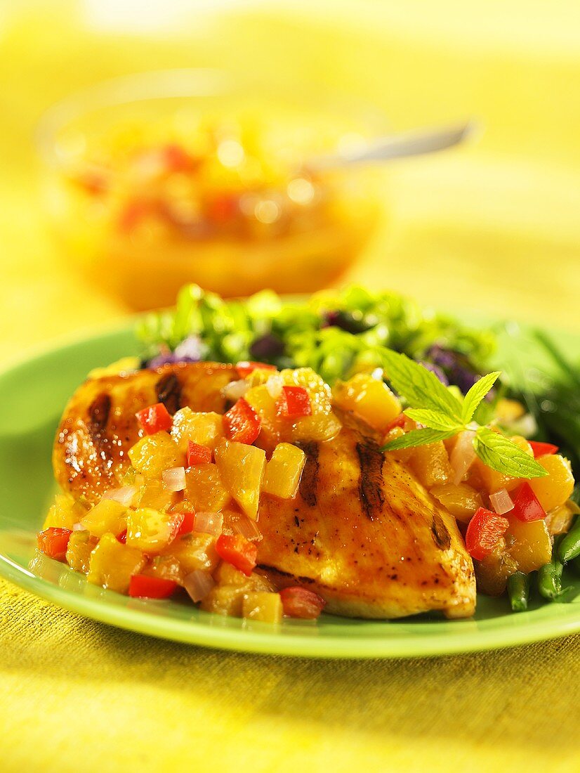Grilled chicken breast with peach salsa and a side salad