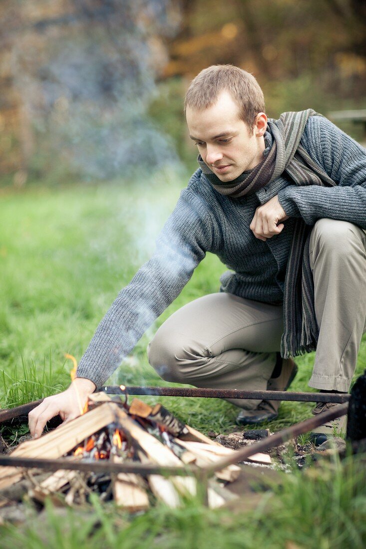 A young man making a fire