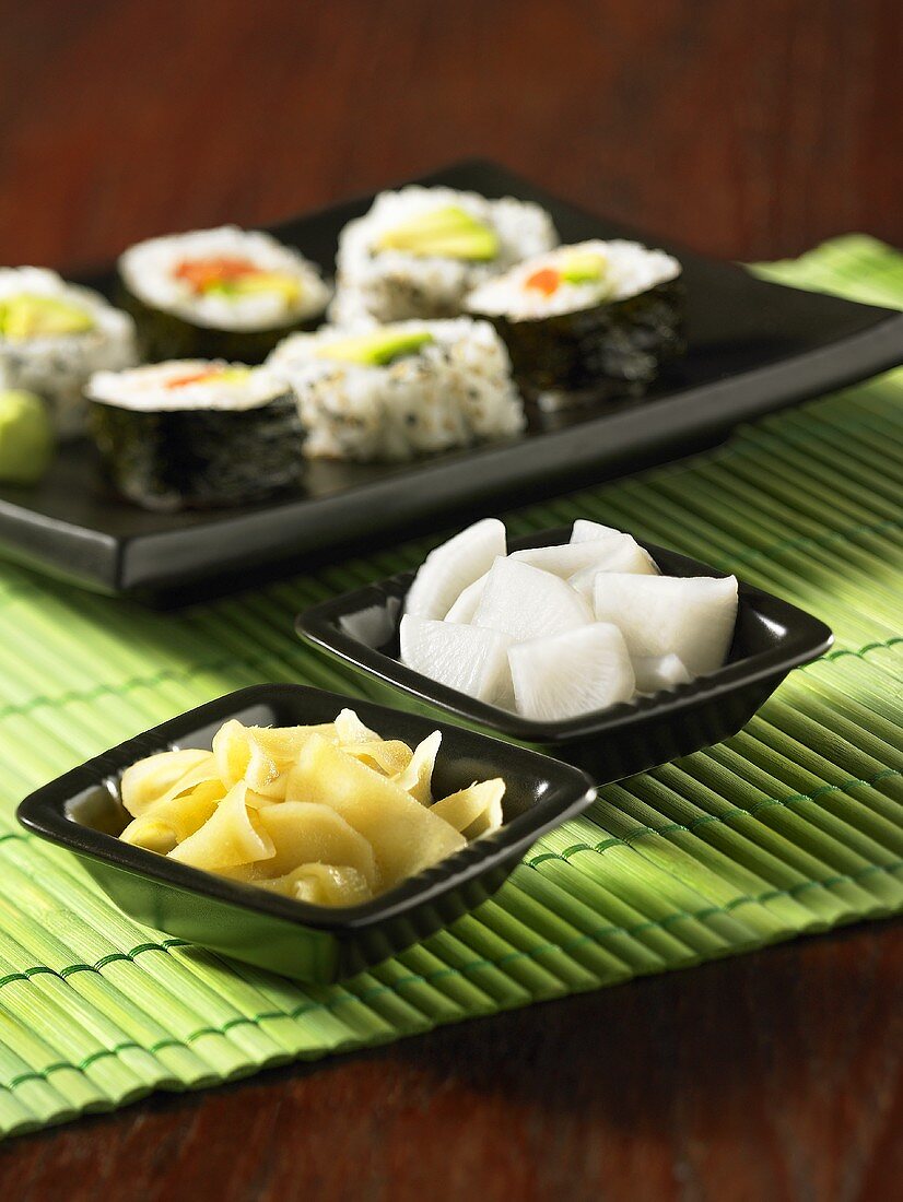 A plate of sushi with ginger and radish