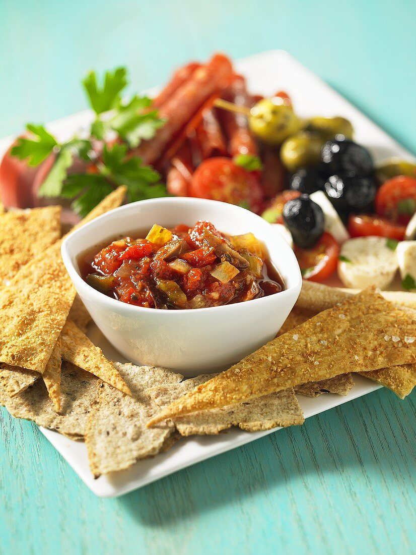 An antipasti platter with bread and tomato salsa