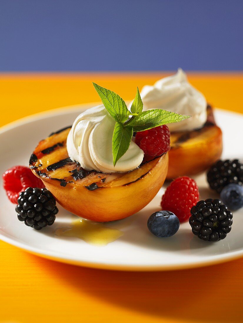 Grilled peaches with cream and fresh berries