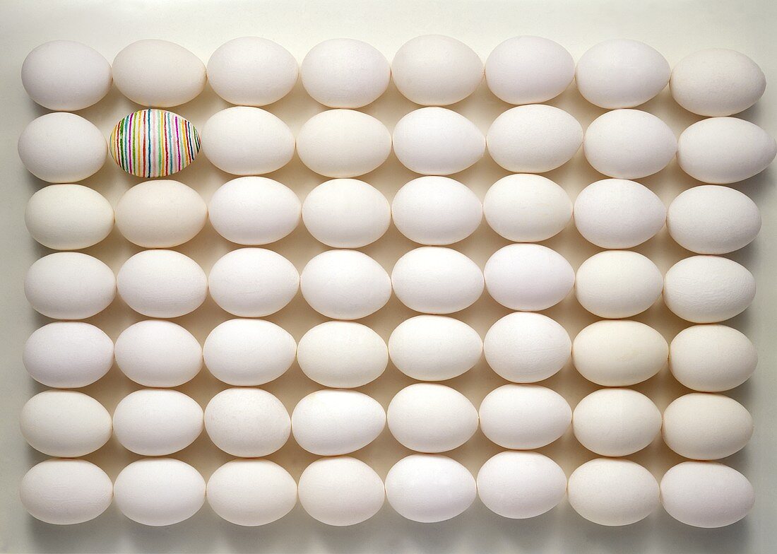 Lots of eggs arranged geometrically, one painted