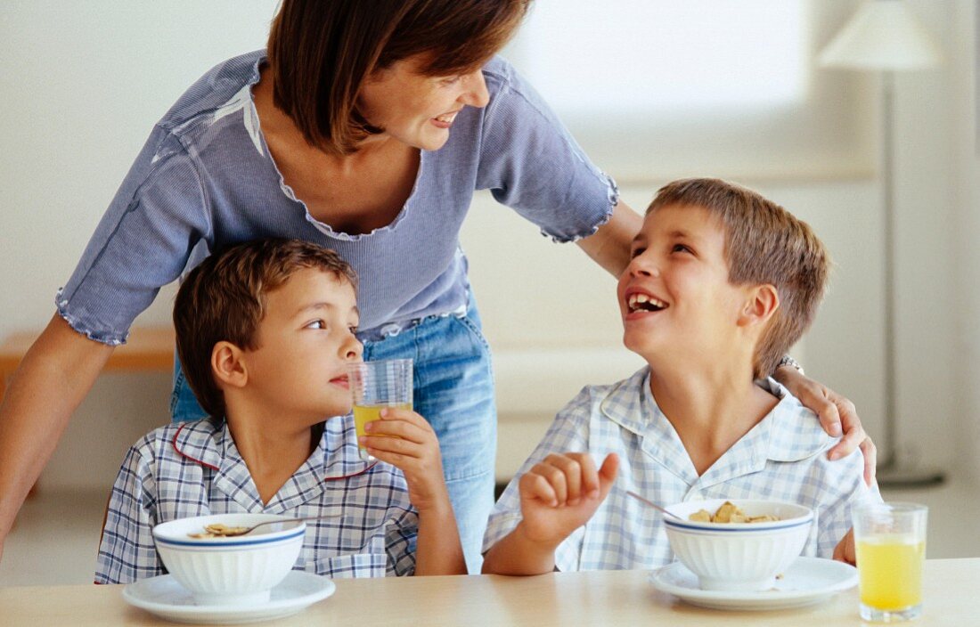 Mutter mit zwei Söhnen beim Frühstück