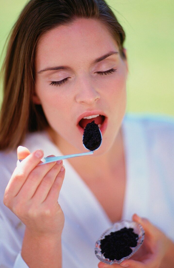 Junge Frau isst Kaviar