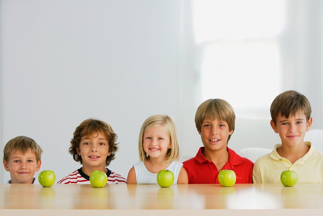 Fünf Kinder mit fünf Äpfeln