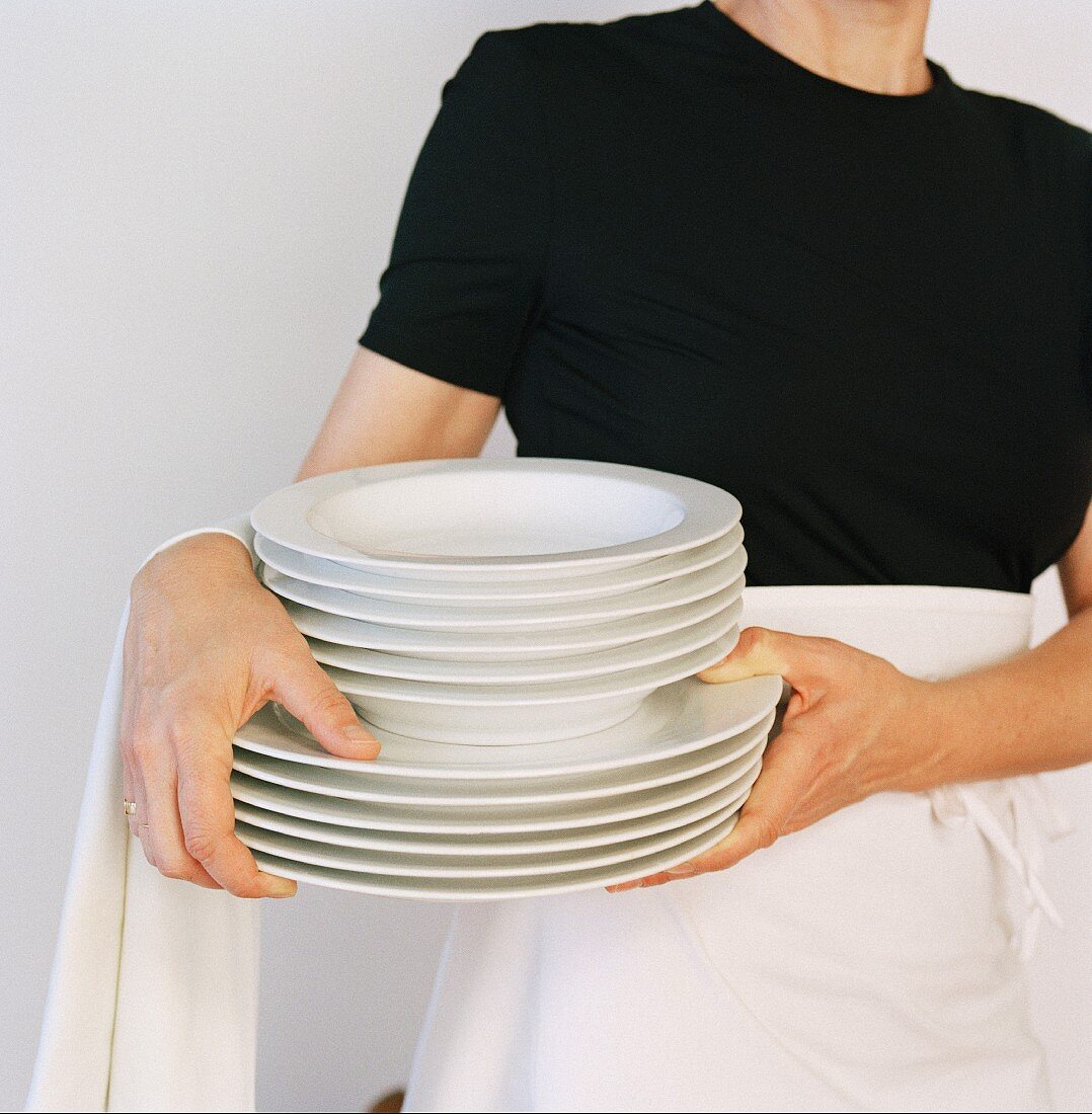 Waitress with stack of plates
