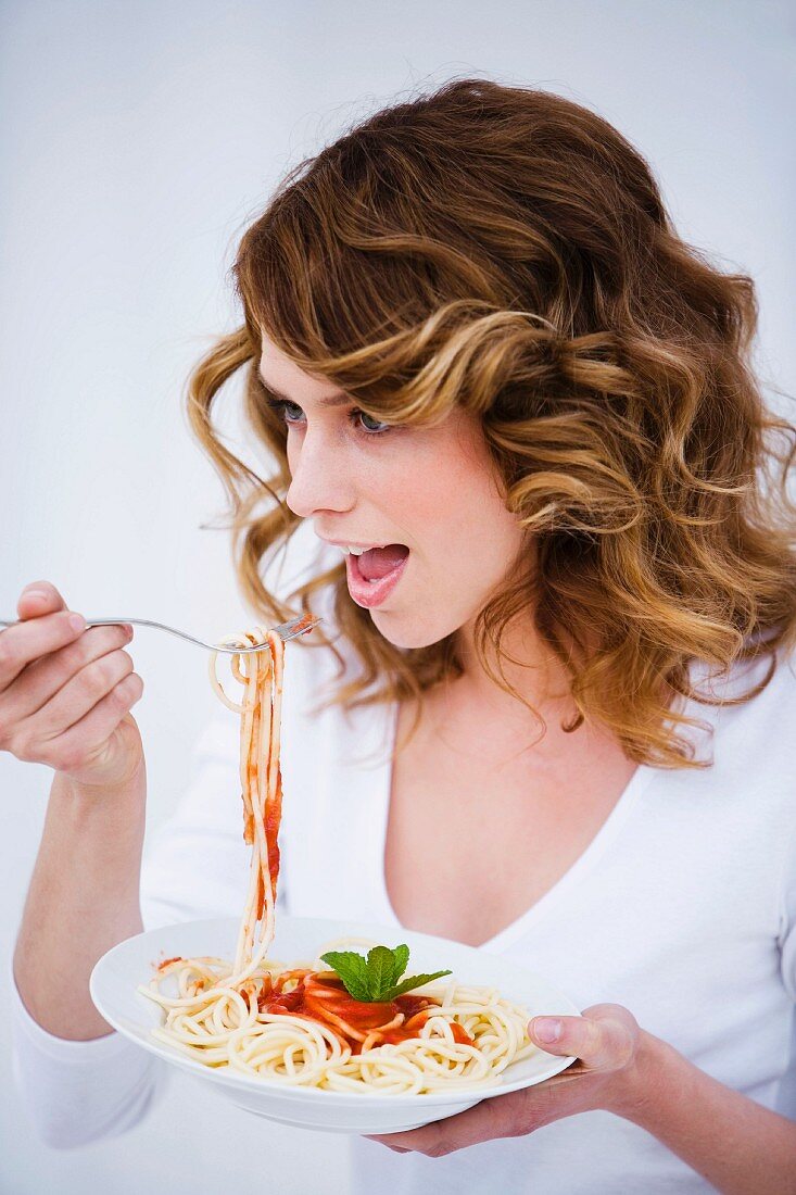 Young woman eating spaghetti