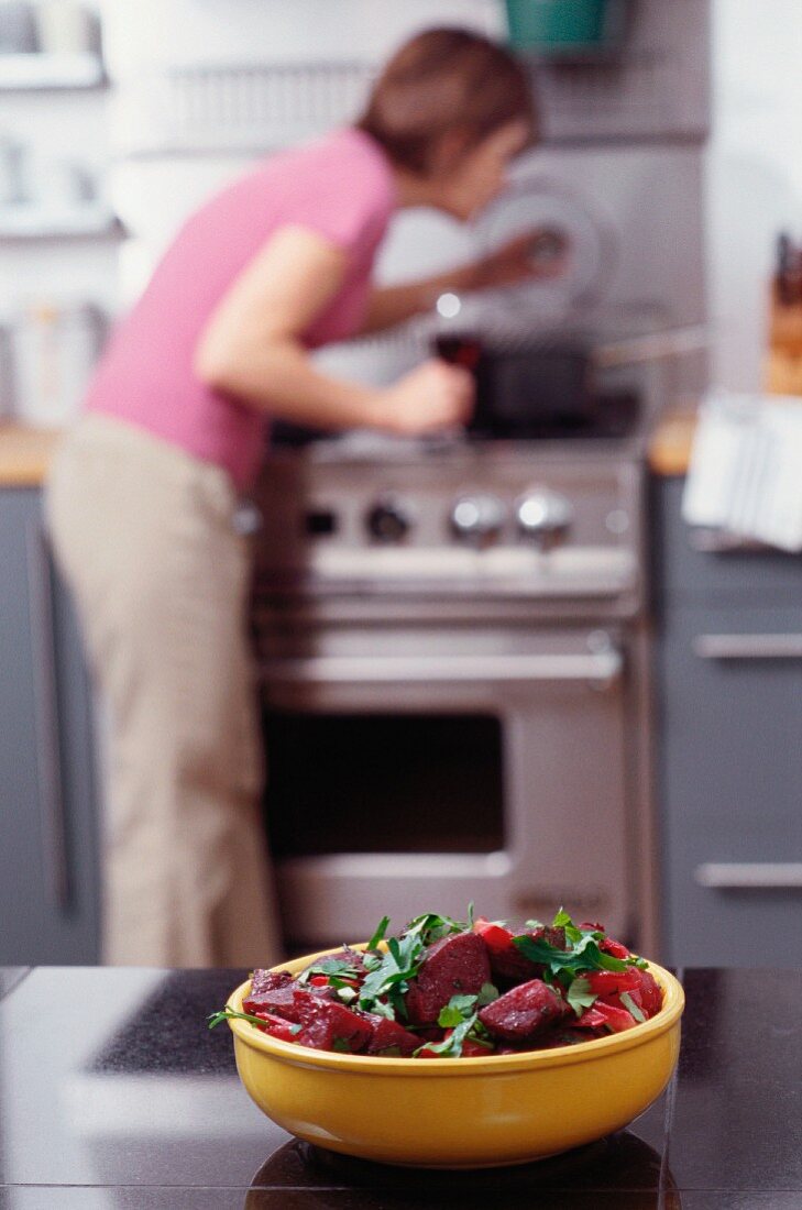 Rote-Bete-Salat mit Frau im Hintergrund